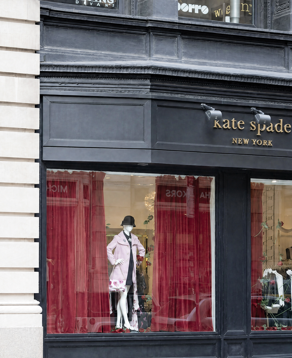 Exterior storefront of a boutique with a mannequin in the window, representing the best places to shop for petite clothing stores.