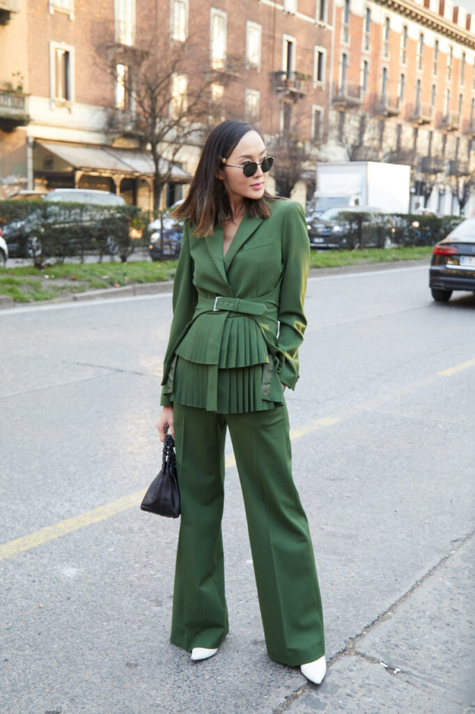 A Petite wearing a monochromatic green suit to create e a colum of color